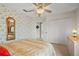 Bedroom showcasing wallpaper, a ceiling fan, and mirrored decor above the dresser at 5516 Willow Bend Trl, Kissimmee, FL 34758