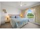 Inviting bedroom featuring a large window with a view of the lake and a ceiling fan at 5516 Willow Bend Trl, Kissimmee, FL 34758