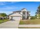 Front exterior showing a two-story home with attached two car garage and manicured landscaping at 5516 Willow Bend Trl, Kissimmee, FL 34758