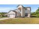 Two-story home with a stucco exterior, arched entryway, and an attached two-car garage at 5516 Willow Bend Trl, Kissimmee, FL 34758