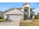 Front exterior showing a two-story home with attached two car garage and manicured landscaping at 5516 Willow Bend Trl, Kissimmee, FL 34758