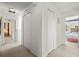 Hallway with carpet and white walls featuring linen closets and access to other rooms at 5516 Willow Bend Trl, Kissimmee, FL 34758