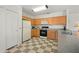 Efficient kitchen with oak cabinets, white appliances, and checkered flooring at 5516 Willow Bend Trl, Kissimmee, FL 34758