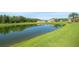 Backyard view showcasing a serene pond surrounded by lush greenery and neighboring homes at 5516 Willow Bend Trl, Kissimmee, FL 34758