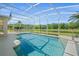 Screened-in pool with a serene view of the pond and surrounding greenery at 5516 Willow Bend Trl, Kissimmee, FL 34758