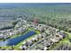 Aerial view of a neighborhood showcasing the homes, lake, and surrounding green spaces in a serene environment at 722 Portofino Dr, Kissimmee, FL 34759