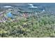 Aerial shot displays a home surrounded by trees, near the lake with a neighborhood in the distance at 722 Portofino Dr, Kissimmee, FL 34759