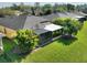An enclosed backyard with a screened-in porch, palm trees and green lawn at 722 Portofino Dr, Kissimmee, FL 34759
