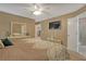 This bedroom features an attached bathroom, neutral walls, and a mounted television at 723 Allison Ave, Davenport, FL 33897