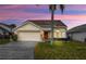 Charming single-story home featuring a two-car garage and well-maintained lawn at 723 Allison Ave, Davenport, FL 33897
