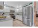 Well-lit kitchen featuring white cabinets, stainless steel appliances, and ample counter space at 723 Allison Ave, Davenport, FL 33897