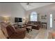 Inviting living room with high ceilings, neutral paint, and comfortable leather furniture at 723 Allison Ave, Davenport, FL 33897