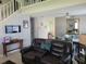 This comfortable living room features a staircase, leather seating, and views of the dining area at 723 Allison Ave, Davenport, FL 33897