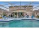 The screened-in pool area offers ample seating, a grill and entertainment space at 723 Allison Ave, Davenport, FL 33897