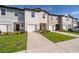 Charming townhomes with colorful facades, well-maintained lawns, and driveways leading to attached garages at 728 Madison Dr, Davenport, FL 33837