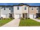 Charming townhomes with colorful facades, well-maintained lawns, and driveways leading to attached garages at 728 Madison Dr, Davenport, FL 33837