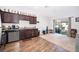 Open-concept kitchen with dark cabinetry, granite countertops, stainless steel appliances, and vinyl flooring at 728 Madison Dr, Davenport, FL 33837