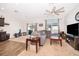 Spacious living room with a ceiling fan, large windows, and open access to the kitchen at 728 Madison Dr, Davenport, FL 33837