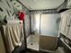 Cozy bathroom featuring a shower with gray tiling, paint with vertical stripes, and a built-in cabinet at 731 Trenton Rd, Lakeland, FL 33815