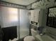 Compact bathroom featuring a shower with gray tiling, and mint green paint with vertical stripes at 731 Trenton Rd, Lakeland, FL 33815