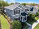 Aerial view of two-story house with lush landscaping, well-maintained lawn, and inviting curb appeal at 7412 Soiree Way, Reunion, FL 34747