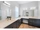 Bathroom featuring dual sinks, vanity area, white countertops and dark wood cabinets at 7412 Soiree Way, Reunion, FL 34747