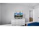 Bedroom featuring dresser, TV, and doors leading to other rooms at 7412 Soiree Way, Reunion, FL 34747