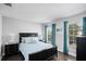 Comfortable bedroom featuring a large bed, wood floors, and natural light from the windows at 7412 Soiree Way, Reunion, FL 34747