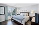 Bright bedroom featuring hardwood floors, large window with blinds and curtains, and two bedside tables at 7412 Soiree Way, Reunion, FL 34747