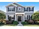 Charming two-story home featuring a well-manicured front yard and black shutters at 7412 Soiree Way, Reunion, FL 34747