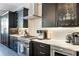 Modern kitchen features stainless steel appliances, and marble countertops, and dark cabinetry at 7412 Soiree Way, Reunion, FL 34747