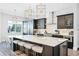 Modern kitchen features a large island with seating, pendant lighting, and stainless steel appliances at 7412 Soiree Way, Reunion, FL 34747