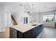 Bright kitchen with an oversized center island, stainless steel appliances, and luxury light fixtures at 7412 Soiree Way, Reunion, FL 34747