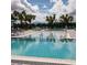 Community pool with lounge chairs and umbrellas surrounded by lush landscaping at 7740 Sandy Ridge Dr # 1, Kissimmee, FL 34744