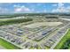 Aerial view of a planned residential community with homes surrounding a lake under a partly cloudy sky at 7793 Clove Hitch Way, Orlando, FL 32832