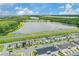 Panoramic aerial view of homes and a lake, with lush greenery and a partly cloudy sky in the distance at 7793 Clove Hitch Way, Orlando, FL 32832
