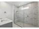 Modern bathroom with a glass-enclosed shower featuring marble-patterned tile and a double sink vanity at 7793 Clove Hitch Way, Orlando, FL 32832