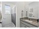 Modern bathroom features a granite countertop vanity, a framed mirror and a walk-in shower at 7793 Clove Hitch Way, Orlando, FL 32832