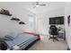 Bright bedroom features a ceiling fan, neutral carpet, and floating shelves with model cars on display at 7793 Clove Hitch Way, Orlando, FL 32832