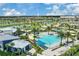 Aerial view of a community pool and clubhouse with a large pool and palm trees at 7793 Clove Hitch Way, Orlando, FL 32832