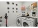 Well-lit laundry room with a Samsung washer and dryer and ample storage space with decorative art on the wall at 7793 Clove Hitch Way, Orlando, FL 32832