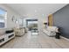 Bright living room featuring white leather furniture, marble floors, and sliding glass doors to a patio with a lake view at 7793 Clove Hitch Way, Orlando, FL 32832