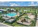 Aerial view of a community pool, splashpad and playground with lush landscaping at 7793 Clove Hitch Way, Orlando, FL 32832