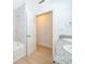 Bright bathroom featuring marble tiling around the tub, a granite countertop, and an open doorway to a closet at 790 Park Ln, Kissimmee, FL 34741