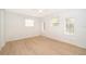 An empty bedroom bathed in natural light showcases multiple windows and sleek, light wood flooring at 790 Park Ln, Kissimmee, FL 34741
