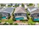 An aerial view of a house with a screen enclosed pool, mature landscaping and a patio at 8204 Fan Palm Way, Kissimmee, FL 34747