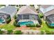 Aerial view of a home with a screened-in pool, patio and mature landscaping at 8204 Fan Palm Way, Kissimmee, FL 34747