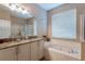 Bright bathroom features double sinks, separate soaking tub, and glass enclosed shower at 8204 Fan Palm Way, Kissimmee, FL 34747
