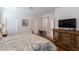 Well-lit bedroom with neutral paint, wood floors, and ample space with adjoining ensuite bathroom at 8204 Fan Palm Way, Kissimmee, FL 34747