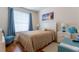 Bright bedroom featuring hardwood floors, neutral colors, a window, and decorative accents at 8204 Fan Palm Way, Kissimmee, FL 34747